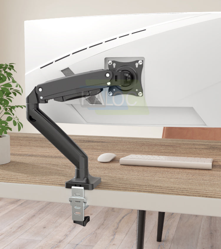 Rear view of a white monitor supported by a black KALOC DS110 arm clamped to a wooden desk.